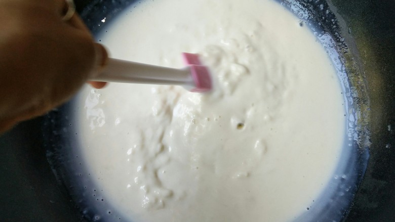 论牛奶的各种吃法之――脆皮炸鲜奶,锅中牛奶在小火加热状态下会慢慢凝固。