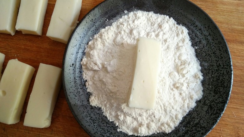 论牛奶的各种吃法之――脆皮炸鲜奶,在切成条的奶冻外面均匀裹上一层薄薄的裹炸粉（生粉）。