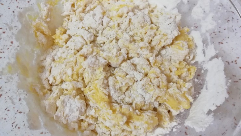果干沙琪玛,蛋液分次加入混合好的面粉中，用筷子挑拌成絮状。