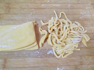 果干沙琪玛,分成四份，每一份都抹上玉米淀粉叠在一起，切成条状。