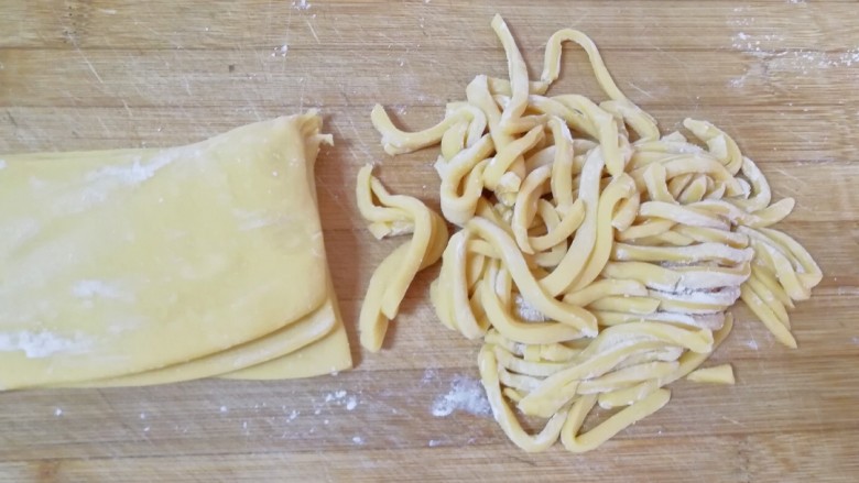 果干沙琪玛,分成四份，每一份都抹上玉米淀粉叠在一起，切成条状。