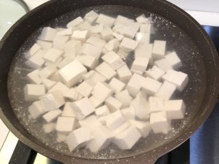 咸蛋黄豆腐,豆腐切丁，煮滚水后沸腾一分钟。然后倒出来沥水