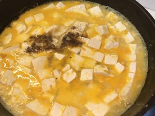 咸蛋黄豆腐,放入胡椒粉，盐，搅拌均匀