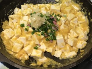 咸蛋黄豆腐,加入葱蒜姜末，搅拌均匀出锅