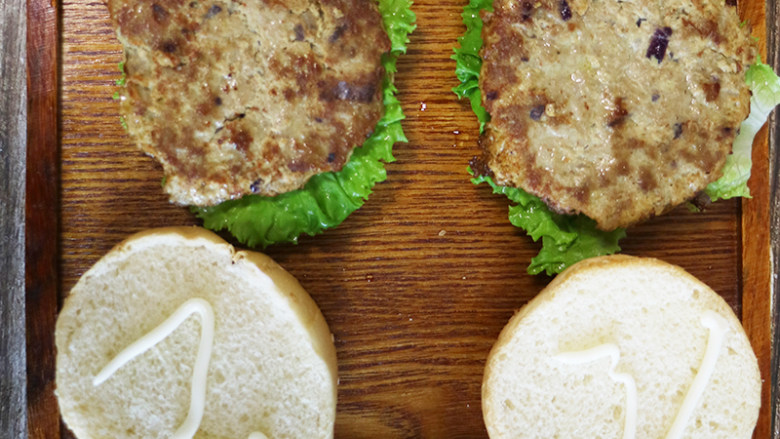 芝士牛肉汉堡,将准备好的汉堡包面包片上均匀地挤涂上色拉酱。