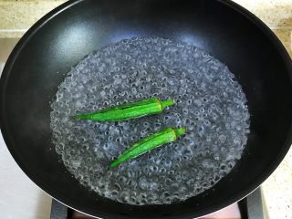 鸡蛋新吃法—抱蛋里脊,锅内倒入适量的清水煮沸，把秋葵放入锅中焯熟