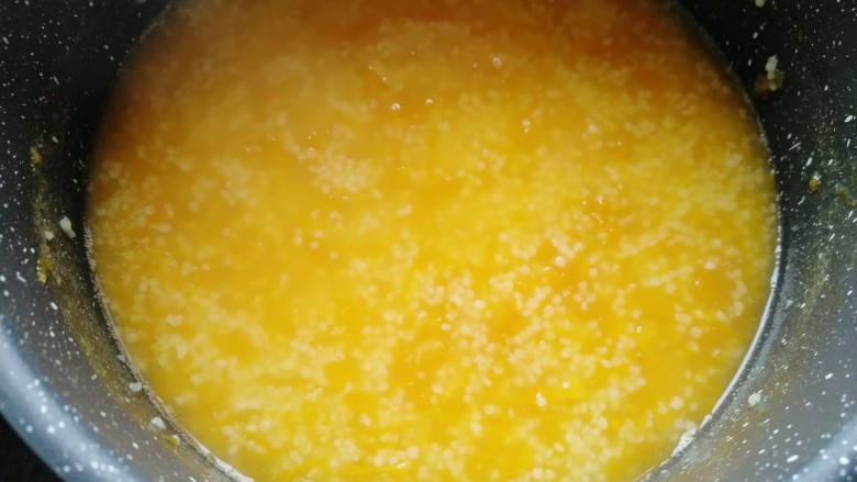 小米南瓜粥,倒入洗干净的小米，改小火慢慢熬制粘稠。