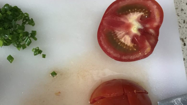 番茄乌鱼（一条鱼两个味道）,煮鱼期间切番茄（可以去皮也可不去皮）剩下的葱切葱花备用