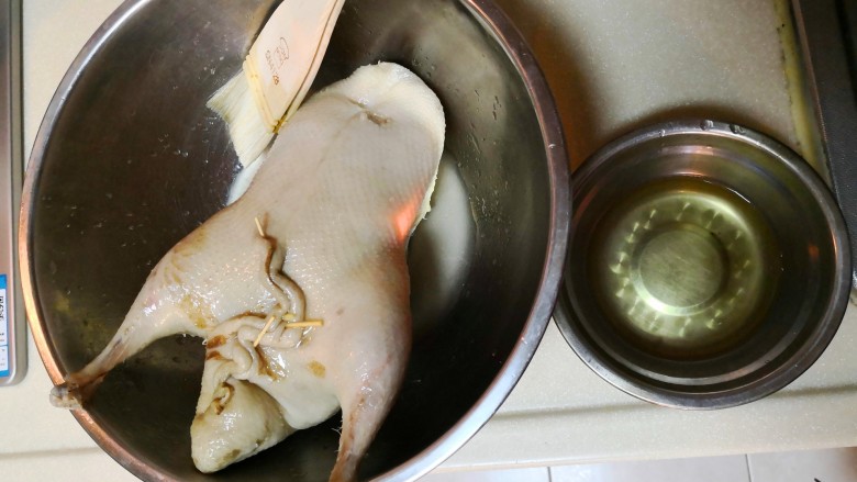 脆皮烤鸭,用刷子将皮水均匀地涂在鸭子的表面。可以间隔一段时间再涂一次。