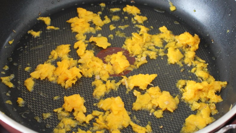 咸蛋黄焗三文鱼,锅里倒点油，下咸蛋黄，用中小火将蛋黄炒断生。
