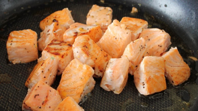 咸蛋黄焗三文鱼,一面煎黄后，逐一翻面，全部翻完就可以关火盛出待用。
注：不要煎过了，煎黄一面就可以了，待会我们还要和蛋黄一起炒。
