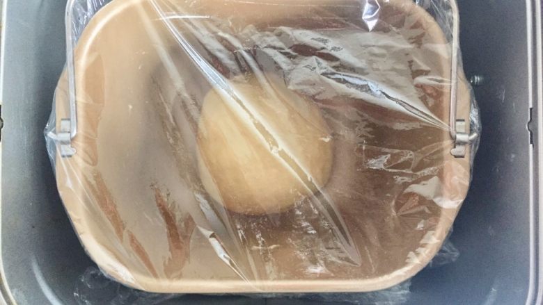 培根芝士汉堡包, 将面团揉圆之后盖上保鲜膜，启动面包机发酵程序设置1小时，手指占粉戳洞不回缩即发酵成功。
