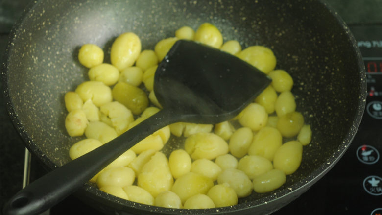 香煎小土豆,用锅铲将一个个小土豆稍微压扁