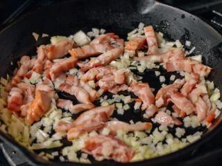 意大利面,在煎锅里用中火加热勺橄榄油。加入培根和洋葱。