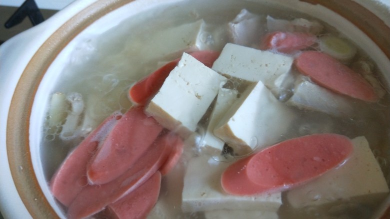 砂锅白肉豆腐奶白菜,这会儿的火腿肠煮好了，加入适量盐。