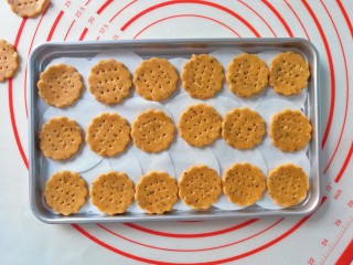 红薯燕麦饼干,在烤盘上铺上硅油纸，家里的整张的硅油纸用完，所以用小的拼起来，将饼干胚依次摆好