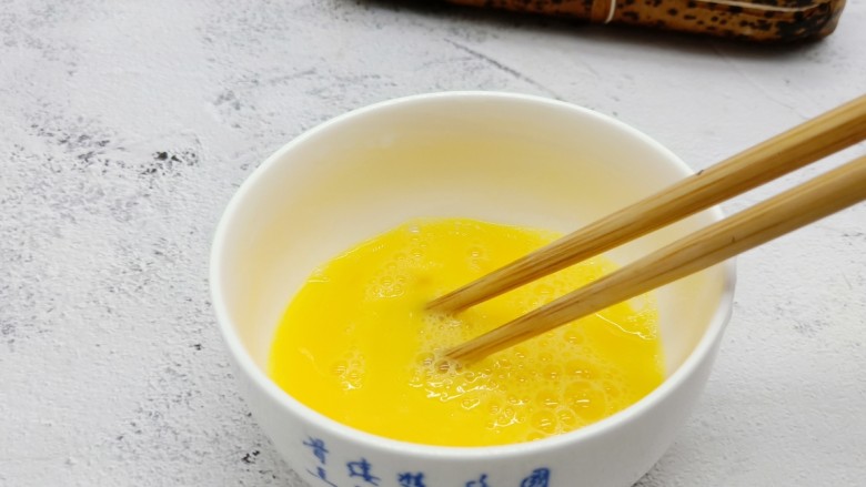 酥香碱水粽,用筷子顺着一个方向把鸡蛋打散。