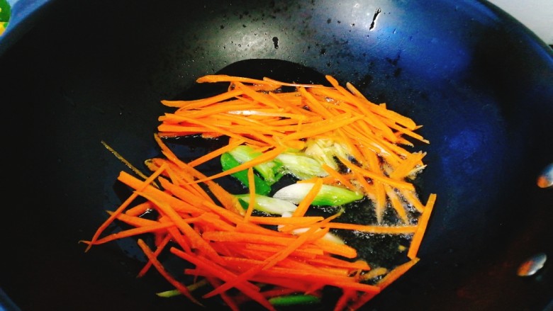 咖喱鸡鲜虾炒面,将葱头 ，姜丝爆香后加入胡萝卜丝炒