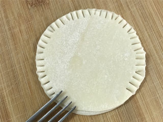 饺子皮版鸡蛋灌饼,然后用叉子把饺子皮四周用力按压，让两片饺子皮粘住。