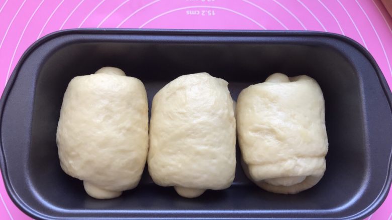 吐司卷•香甜拉丝超柔软,把三个小面卷放进面包模具里，进行二次发酵。