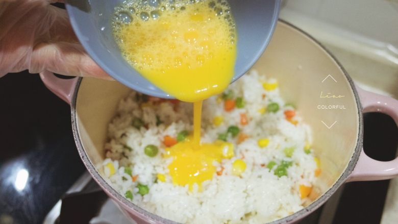 LC珐琅锅菠萝炒饭,一个鸡蛋打散，加一丢丢盐倒入饭上，炒匀。