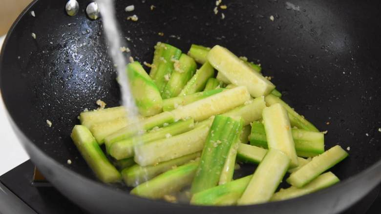 绿色清新的家常小菜—蒜蓉炒丝瓜,顺锅边加入适量热水，大火煮开。