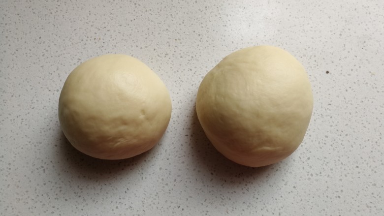 花环豆沙包,然后把揉好的面团分成两份，其中一份比另一份重约30克左右。