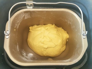 南瓜红豆排包,除黄油外的面团材料按先液体后粉类的顺序放入面包机，揉一个程序后加入软化的黄油揉到扩展阶段