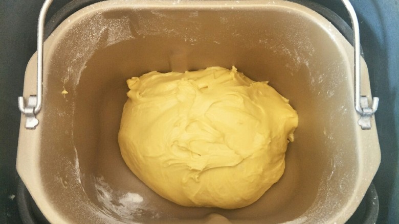 南瓜红豆排包,除黄油外的面团材料按先液体后粉类的顺序放入面包机，揉一个程序后加入软化的黄油揉到扩展阶段