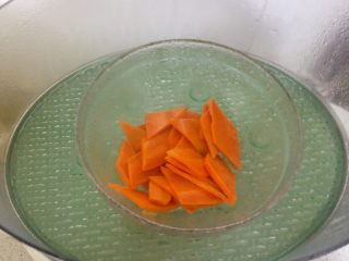 芦笋腐竹炒肉片,为了省时间，先蒸熟胡萝卜。喜欢脆甜的话，这步可省略。