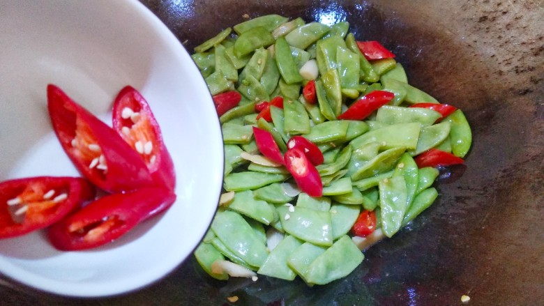 辣炒扁豆,打开过锅盖，放入红辣椒翻炒15秒。