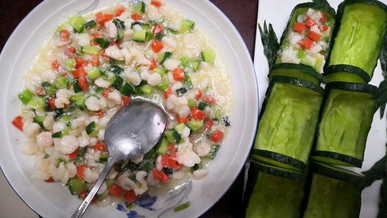 【翠竹报春】,装盘，将炒好的虾仁用勺子装入黄瓜中。