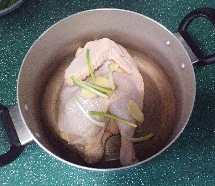 口水鸡,葱姜、鸡子洗净后放入锅中