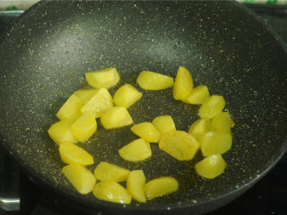 土豆炒茄子,锅中放入油，烧至五成热，将土豆放进去，中小火炸至金黄色，捞出备用
