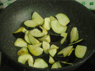 土豆炒茄子,将锅里的油抹干净后烧热，茄子片放进去，煎至表面微黄