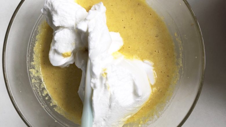 玉米面椰蓉蒸糕,挑1/3的蛋白霜倒入蛋黄面糊中，刮刀用翻拌的手法拌均匀