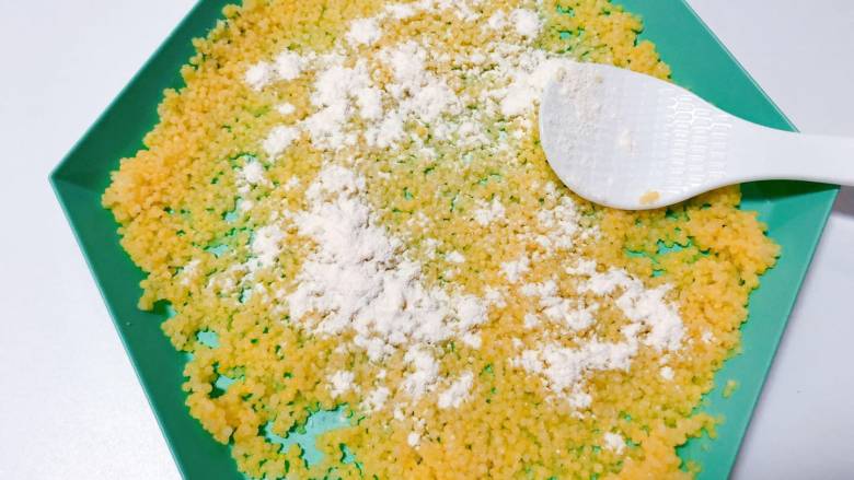 【宝宝辅食】干贝小米疙瘩汤,面粉分批撒在小米上，用勺子背部使小米裹上面粉；