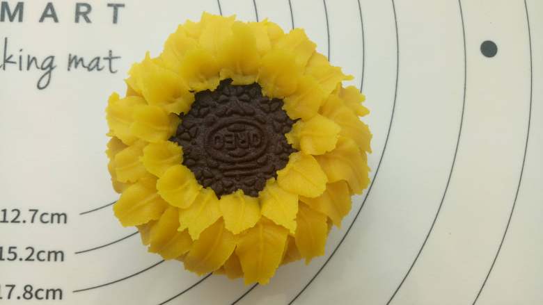 向日葵纸杯蛋糕 ,在两个花瓣之间挤上第二层花瓣，同样规律再挤上第三层、第四层。根据个人的喜好挤3-5层即可。
