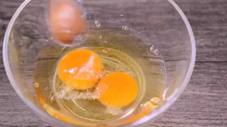 早餐新吃法！这道懒人抱蛋煎饺是你的至尊首选,碗中打入鸡蛋，撒入盐，搅拌均匀 