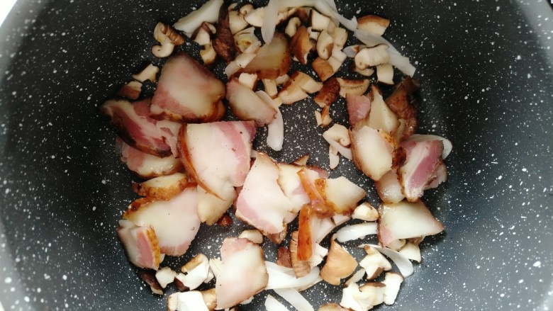 土豆腊肉香菇饭,倒入腊肉翻炒均匀。
