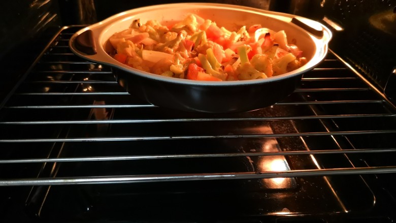 烤咖喱花菜胡萝卜,烤箱预热至220度，烤8-10分钟。