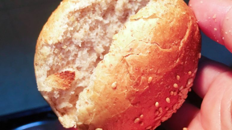 猪排玉米香肠汉堡包,用刀从面包中间切开成两半。
