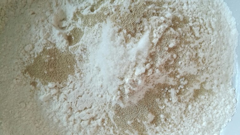 盘丝花卷,把白糖和酵母加入面粉里，搅拌均匀