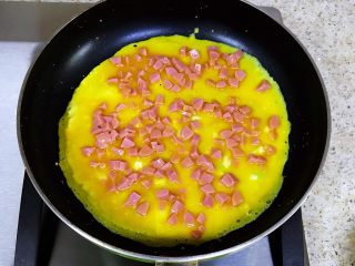 鸡蛋新吃法-双色蛋卷,平底锅加热倒入一层薄薄的油，倒入蛋黄液，晃动平底锅，让蛋液摊匀，小火慢煎