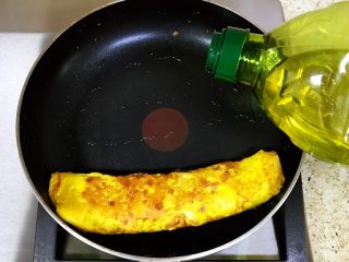 鸡蛋新吃法-双色蛋卷,表面稍凝固后卷起，移位到平底锅一头，再倒入适量的橄榄油