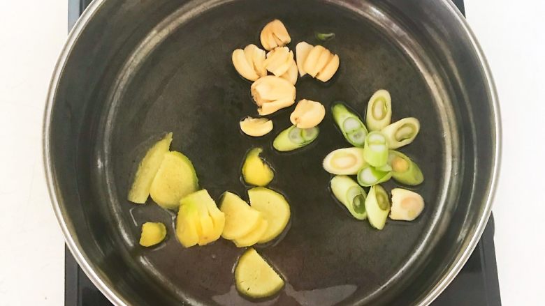 家常美味酸菜鱼,炒锅烧热后加入1勺大豆，油温6分热的时候加入切好的葱姜蒜，炒出香味