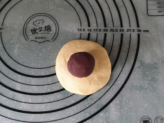 紫薯花面包#冷藏发酵法#,取份面团按压成四周簿中间厚的圆片，再放上一个紫薯馅