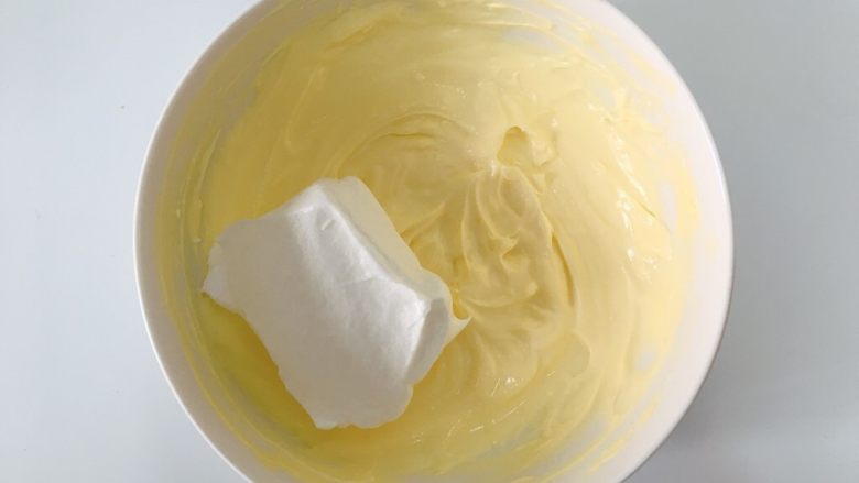 提拉米苏,取三分之一的蛋白霜放入奶酪糊中搅拌均匀。