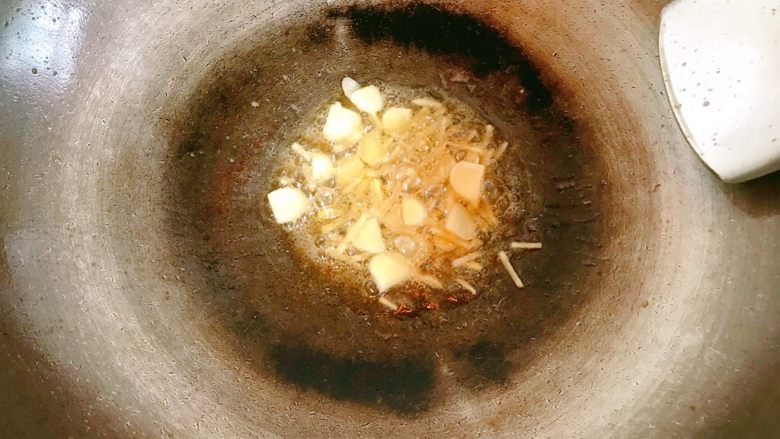 煎煮草鱼,锅内剩些许油，放入蒜片和姜丝，炒香。