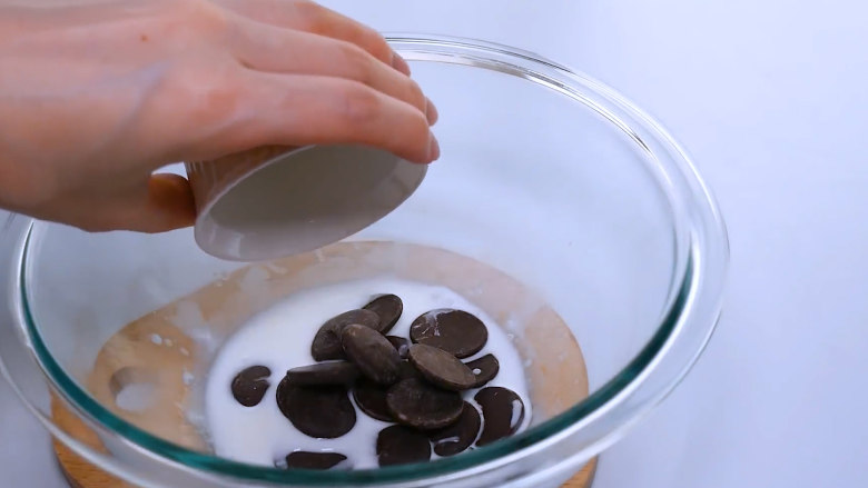 巧克力马卡龙,准备马卡龙夹层。30g热牛奶中加入50g巧克力，搅拌至巧克力完全融化。